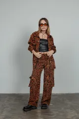 Pantalón cargo de tiro medio a bajo con estampado animal print color marrón y negro. Tiene bolsillos cargo y pretina elástica en la espalda.