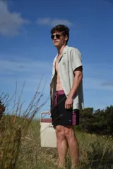 Short de baño negro con cintura elastizada color borgoña y cordón de ajuste. Presenta un bolsillo lateral con detalle de etiqueta con logo.