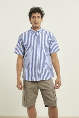 Camisa de manga corta con diseño de rayas verticales en azul y blanco, cuello abotonado y bolsillo frontal en el pecho.