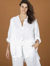 Camisa blanca oversize de lino con cuello clásico, manga larga y cierre frontal con botones.