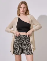 Short negro con estampado floral en tonos beige, con pretina ancha elastizada en punto smock y bolsillos laterales.