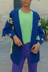 Sacón azul de algodón y acrílico con bordados de motivos tropicales en frente, espalda y mangas, y flecos en las mangas.