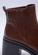 Bota de caña baja color negro, con elástico lateral, punta redonda y taco plataforma.