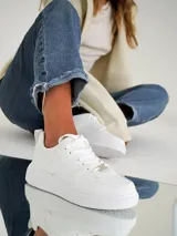 Championes blancos de estilo urbano, con suela de plataforma y cordones.