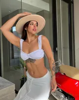 Top blanco con breteles finos y volados en el escote.