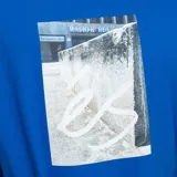 Remera azul con estampa fotográfica de un bloque de cemento con el logo de éS.
