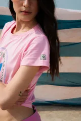 Remera rosa de algodón con estampa circular en azul con un caballo parado de manos y la leyenda "The Ranch Dress Code".