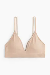 Soutien de diseño minimalista confeccionado en tejido suave sin costuras, con escote en V profundo, breteles ajustables y copas con relleno extraíble.