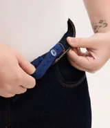 Pantalón de jean corte recto, color azul oscuro, con cintura fija, trabillas para cinturón, bolsillos funcionales y cierre frontal con botón y cremallera.