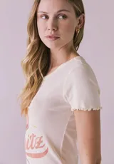 Remera blanca de algodón con cuello redondo y mangas cortas con volados. Estampado frontal con la frase "Love at first Spritz" y un dibujo de una copa de Aperol Spritz.