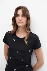 Remera blanca de algodón con cuello redondo y strass plateados formando pequeños dibujos.