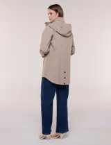 Campera impermeable Gallery de color beige, con capucha plegable, cierre frontal oculto con botones a presión, bolsillos delanteros y cordón de ajuste en la cintura.