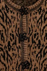 Chaqueta de punto con diseño jacquard de estampado animal en tonos marrón y negro. Presenta cuello redondo, manga larga y cierre frontal con botones decorados con abalorios.