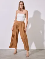 Pantalón fluido color marrón, marca Cupio, con pretina elastizada en punto smock y largo de pierna plisado.