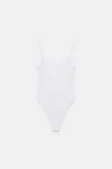 Body de cuello cuadrado con tirantes finos, confeccionado en tejido elástico con cierre inferior mediante botones a presión.