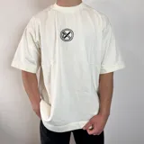 Remera negra de algodón pesado, corte oversize, con un gran estampado en la espalda en blanco y negro que muestra la parte inferior del rostro de una persona con un gorro tejido cubriendo los ojos y un cigarrillo en la boca.