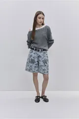 Sweater de punto color tostado, de calce relajado, con escote asimétrico decorado con ojalillos metálicos y mangas largas.