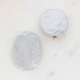Aros colgantes plateados con forma irregular y textura martillada.