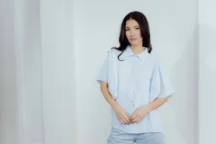 Camisa de lino color tostado, con cuello camisero y cierre frontal de botones. Se caracteriza por sus mangas cortas amplias y voluminosas que aportan un diseño fresco y liviano.