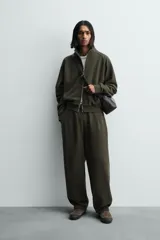 Pantalón jogger de algodón color verde oscuro, con efecto lavado, corte balloon fit y cintura elástica. Presenta bolsillos delanteros y bolsillos traseros de plastrón.