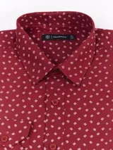 Camisa de manga larga marca Cuatro Ases, color gris con estampado de pequeños triángulos blancos. Presenta cuello clásico, cierre frontal con botones y puños abotonados.