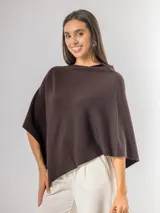 Poncho de corte holgado y diseño minimalista, confeccionado en tejido liviano de color beige, con cuello redondo y caída fluida.