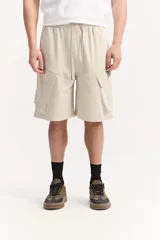 Bermuda cargo de algodón sin frisa color beige, con cintura elastizada, cordón ajustable y amplios bolsillos laterales con solapa.