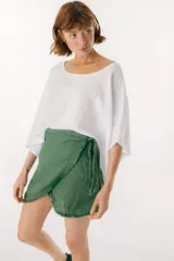 Blusa blanca de lino, con escote bote y corte amplio y holgado.