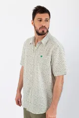 Camisa de manga corta con estampado de líneas verdes sobre fondo blanco, confeccionada en tela crepé.