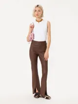 Pantalón de cuero marrón con corte ajustado y aberturas en el ruedo.