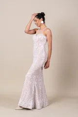 Vestido largo de tul color nude, con bordados blancos de diseño floral. Presenta escote redondo, corte ajustado y falda con vuelo.