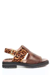 Sandalia abierta de cuero liso marrón con pala ancha y tira trasera ajustable con hebilla metálica en estampado animal print. Presenta una suela de goma robusta con plataforma baja.