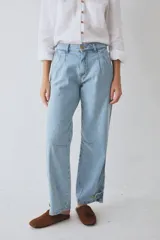Pantalón de jean estilo bombacha de campo, con pinzas frontales, pespuntes a contratono y botones en los tobillos para ajustar el ruedo. Diseño de tiro medio con corte holgado.