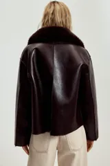 Cazadora reversible de corte recto, con cuello solapa, manga larga y cierre frontal con botones. Presenta un acabado efecto piel con textura y bolsillos delanteros de doble vivo.