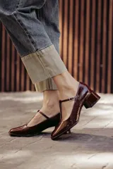 Zapatos de charol color bordó, con diseño tipo T-bar, punta cuadrada y tacón bajo de 4 cm.