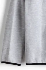 Campera deportiva de tejido funcional con efecto neopreno y tecnología DryMove para absorción de sudor. Presenta diseño de manga raglán, capucha, cierre frontal, bolsillos laterales con cierre y costuras selladas. Incluye elástico en puños y ruedo.