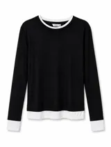 Remera de manga larga de color negro con cuello redondo, puños y dobladillo en contraste de color blanco, simulando un efecto de doble capa.