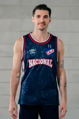 Musculosa de básquet Umbro del Club Nacional de Football, modelo alternativa 2025. Diseño en color azul marino con patrón sutil estampado, cuello redondo y sisas en rib con líneas blancas y rojas. Incluye el logo de Umbro, el escudo del club y la inscripción "Nacional" en el frente.