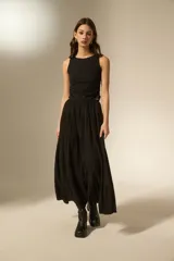 Falda larga de corte amplio con diseño de frunces horizontales y caída fluida.