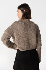 Sweater crop de tejido de punto color chocolate, con cuello redondo y diseño de rombos en relieve. Presenta puños y ruedo acanalados.