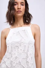 Vestido corto blanco de broderie con breteles finos y corte recto.