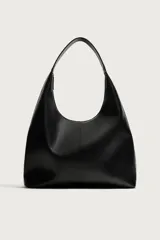 Bolso tipo shopper color negro con diseño liso, asa de hombro y compartimento principal con cierre de cremallera.