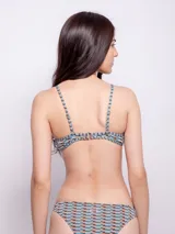 Conjunto de bikini estampado con motivos geométricos en tonos celeste y naranja. El corpiño es de corte triangular con breteles finos regulables y copas desmontables. La bombacha es de corte clásico.
