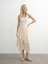 Falda midi de encaje color crema con diseño asimétrico de capas superpuestas y corte irregular.