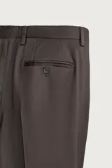 Pantalón de traje regular fit negro, confeccionado en lana italiana, con bolsillos laterales, bolsillos traseros de vivo con botón y cierre frontal de cremallera y botón.