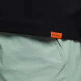 Remera de manga corta color negro, con cuello redondo y bolsillo frontal en el lado izquierdo. Presenta un diseño básico y versátil.