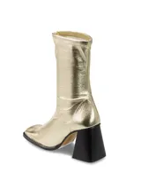 Bota corta plateada de cuero con efecto metalizado, caña elastizada, punta cuadrada y tacón geométrico negro.