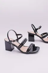 Sandalias rojas de charol con dos tiras en el empeine, tira fina con hebilla en el tobillo y tacón cuadrado.