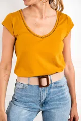 Remera de manga corta color mostaza, con escote en V ribeteado con detalle calado.