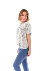 Conjunto de pijama de algodón color champagne, compuesto por una remera de manga corta con cuello henley y bolsillo en el pecho, y un pantalón capri a rayas horizontales celestes y blancas.